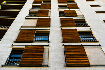 Industrial Facade with Repetitive Yellow Wooden Shutters Creating a Symmetrical and Textured Design