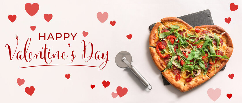 Board with tasty heart shaped pizza and cutter on white background