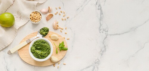 Fresh pesto sauce and ingredients on light background with space for text, top view
