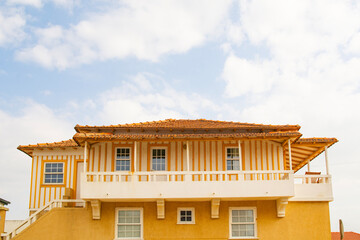 yellow striped house on the coast