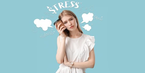 Tired stressed young woman with cup of coffee on light blue background