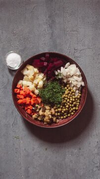 Vinegret salad making process stop motion animation vertical video. Ingredients - boiled potato, carrot, beetroot, onion, pickled cucumber, canned peas, greens. Vegan and vegetarian food concept