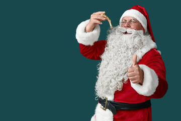 Santa Claus eating tasty pizza and showing thumb-up on green background