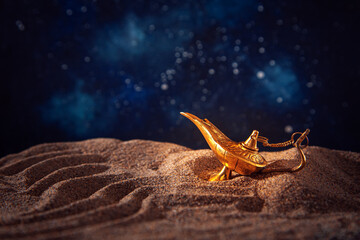 Precious golden magic lamp on the sand. Arabian night.