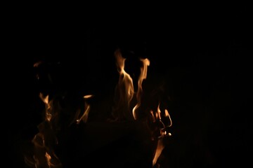 Dull golden orange flames against black background with copy space