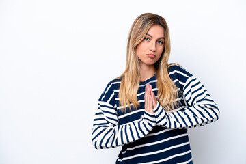 Young Uruguayan woman isolated on white background keeps palm together. Person asks for something