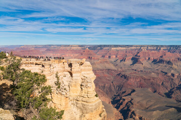Grand Canyon national park, Arizona. Visitors admiring the panoramic view from Mather Point, south rim, in November, bright light and partly cloudy.