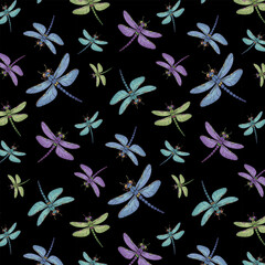 Multi-colored dragonflies in a pattern.Vector seamless pattern with colorful dragonflies on a black background.