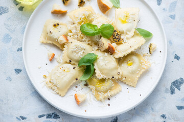 Italian ravioli served with parmesan and belper knolle cheese on a white plate, horizontal shot, middle closeup