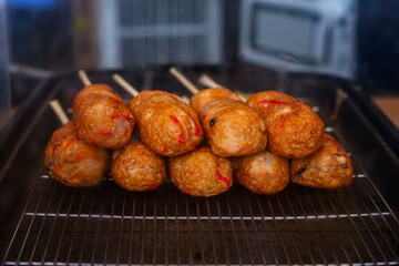 Fish street food on a stick at a fish market in Japan. Delicious local delicacies. Close-up.