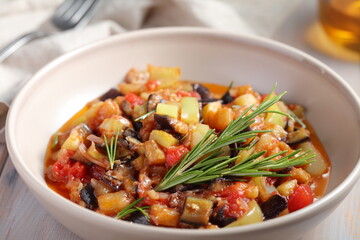 Bowl of ratatouille with eggplants, tomato, pepper, summer squash decorated with fresh rosemary