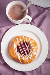 Danish pastry with jam and a cup of hot chocolate