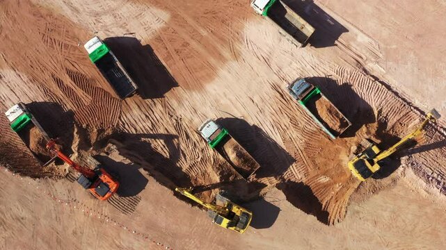 Aerial view road motor grader flatting dirt road surface, Motor grader road construction grader industrial machine construction site new road, Aerial view group excavator working on construction site.