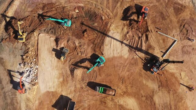 Aerial view road motor grader flatting dirt road surface, Motor grader road construction grader industrial machine construction site new road, Aerial view group excavator working on construction site.