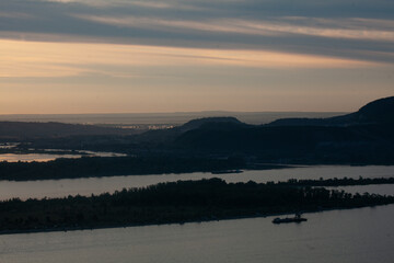 Golden hues reflect on the Vilga River as the day fades, showcasing a serene landscape of natures beauty.