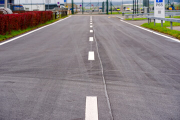 Obraz premium Close-up of freshly tarred road at the airport of Zurich Kloten with white road markings on a foggy autumn day. Photo taken December 1st, 2024, Zurich Kloten, Switzerland.