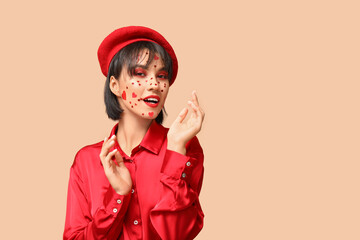 Beautiful young young woman with creative makeup for Valentines Day on beige background