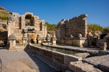 Obraz premium Rows of columns in Perge, Antalya, Turkey. Remains of colonnaded street in Pamphylian ancient city.Rows of columns in Perge, Antalya, Turkey. Ancient Kestros Fountain. Aksu, Antalya