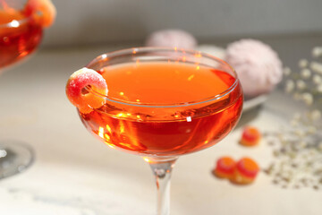Glass of tasty cocktail with marmalade on light table, closeup. Valentine's Day celebration