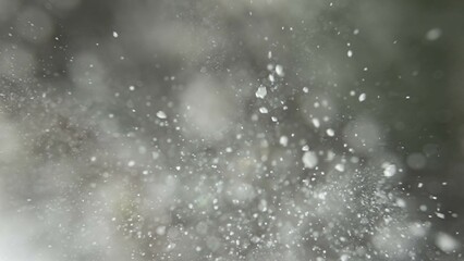 Many dust flour particles floating in light on empty background with spotlight from above.