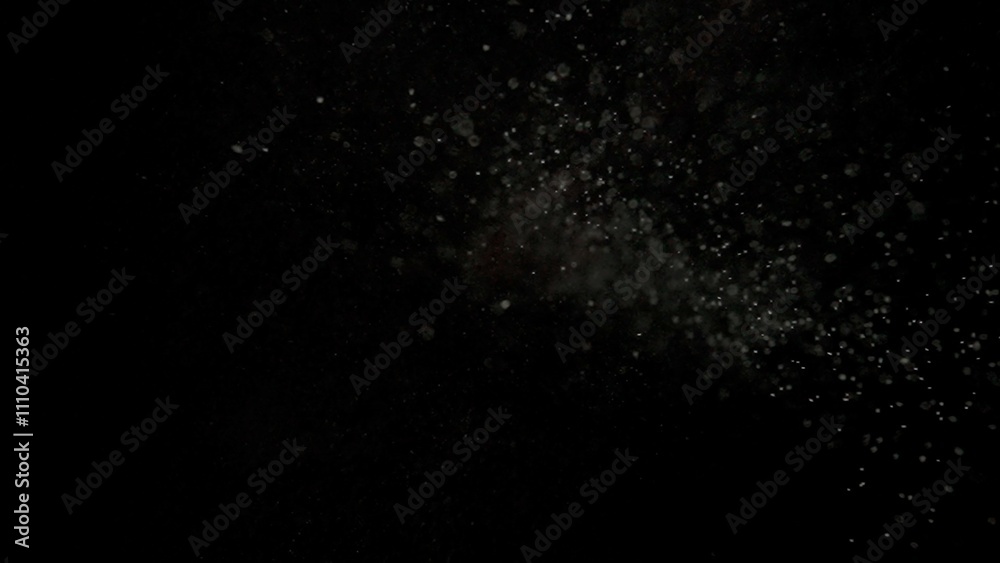 Wall mural many dust particles floating falling from top in light on empty black background with spotlight from