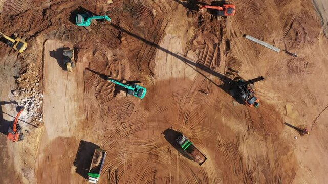 Aerial view road motor grader flatting dirt road surface, Motor grader road construction grader industrial machine construction site new road, Aerial view group excavator working on construction site.