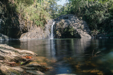 Serene Waterfall Cascading into Tranquil Pool Surrounded by Nature