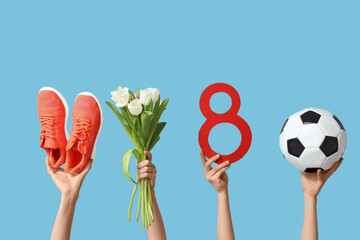 Female hands with paper figure 8, shoes, soccer ball and tulip flowers for International Women's...
