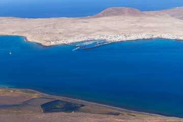 La Graciosa Island in the Canary Islands and the main town of Caleto Del Sebo with the Volcanic mountain in the background, viewed from Lanzarote.