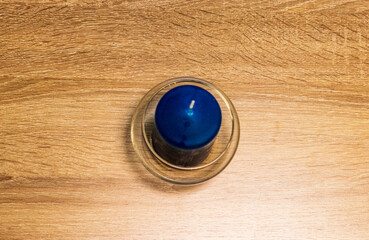 Close up shot of the blue, scented candle on the wooden table. Concept
