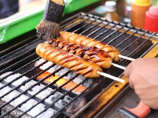Someone is grilling sausages on a special grill stove