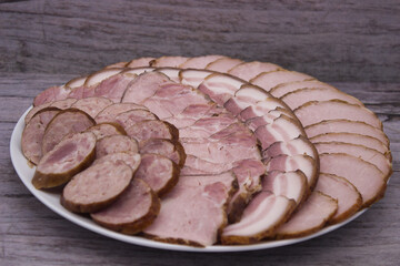 Platter of sliced smoked meats on rustic background