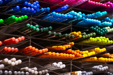 A diverse set of colored pencils is beautifully lined up on a rack