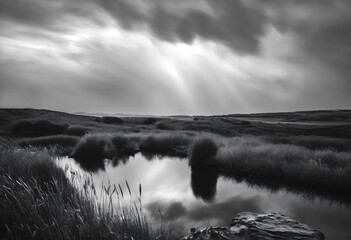 Scenic view of a tranquil river in a monochrome landscape under dramatic clouds at dusk