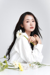シャツを着た若い女性の花と撮影したシックなビューティーポートレート