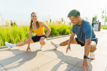 Couple engages in outdoor stretching routine during sunny morning at a park