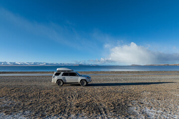 Offroad car at the side of beautiful lake in tibet,China