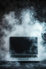 A laptop computer surrounded by smoke on a dark background.