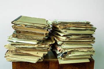 Old, chaotically folded papers, drawings, price lists on a light background, like waste paper.