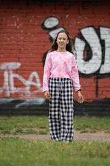 A young beautiful girl frolics in a summer park.