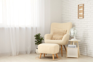 Modern electric fans on shelving unit and chest of drawers in living room