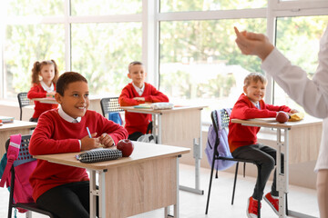 African-American schoolboy having lesson in classroom