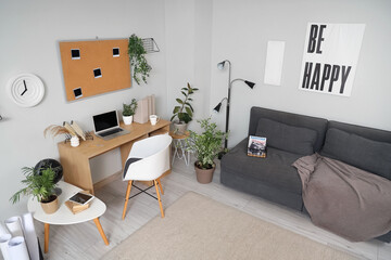 Fototapeta premium Interior of office with workplace, plants and sofa