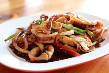 Stir-Fried Squid with Red Curry Paste in white plate, thai food