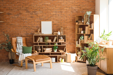 Armchair, chest of drawers, shelving units with books and houseplants in interior of home library
