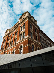 Historic Red Brick Building with Modern Architectural Elements Under a Vibrant Blue Sky
