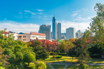 Fototapeta premium A park on Yantai Mountain and city skyscrapers in the distance, Shandong, China