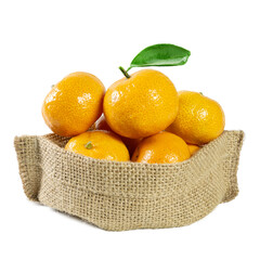 A bunch of vibrant tangerines placed in a rustic burlap sack. One of the fruits on top has a green...