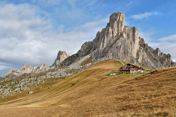 Autumn mountains with hut in Italian Dolomites autumn landscape