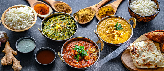 Composition with Indian dishes: madras paneer, palak paneer and shahi paneer with basmati rice served in original indian karahi pots